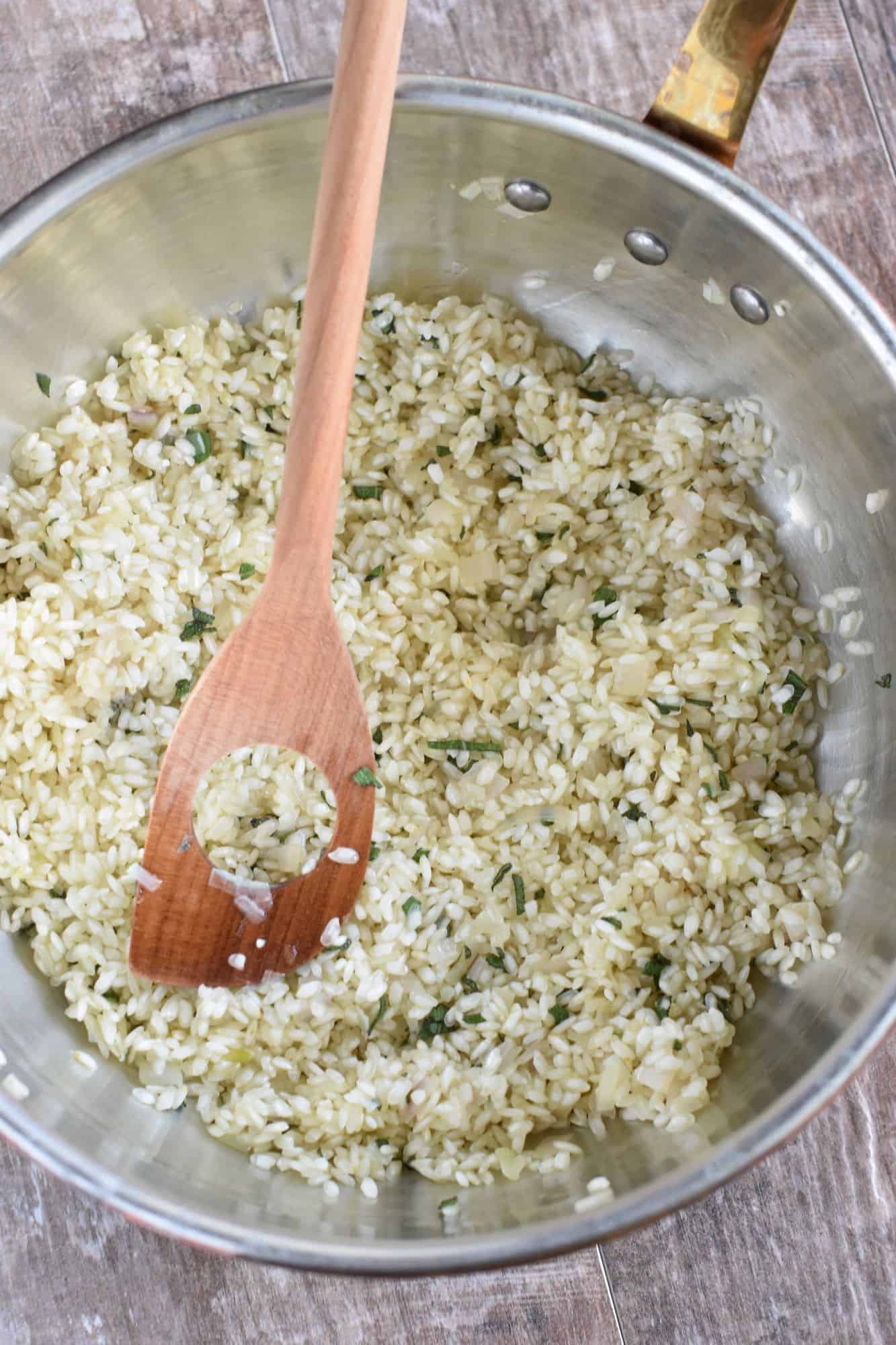 Arborio rice stirred into the sage, shallot and olive oil mixture to coat