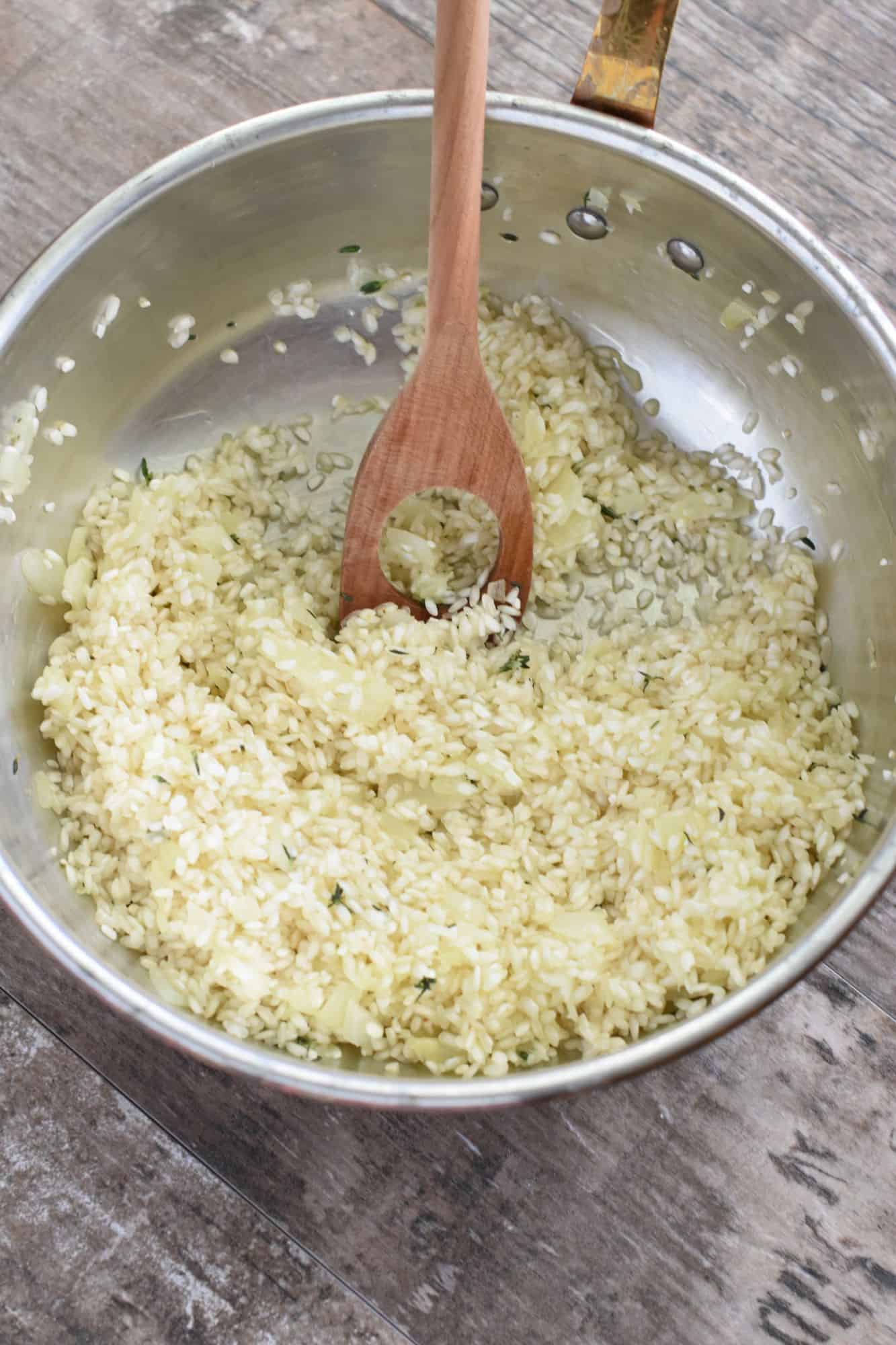 rice being stirred in with a wooden spoon