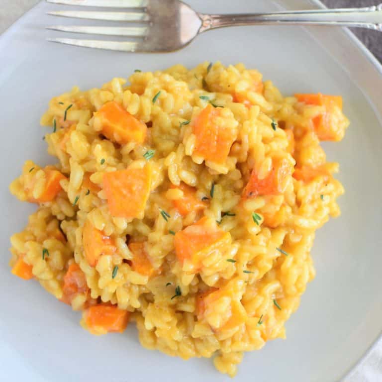 closeup overhead of risotto on white plate with fork