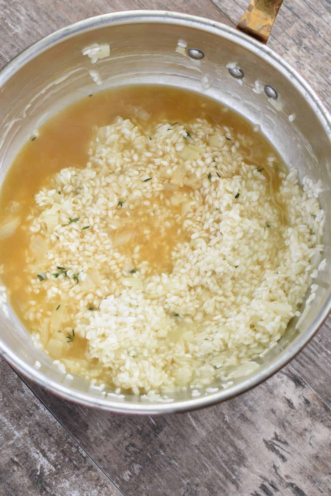 broth added to the rice in the pan