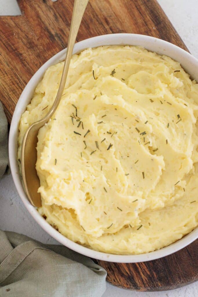 Creamy bowl of dairy free mashed potatoes - close up image with a gold spoon in the bowl.