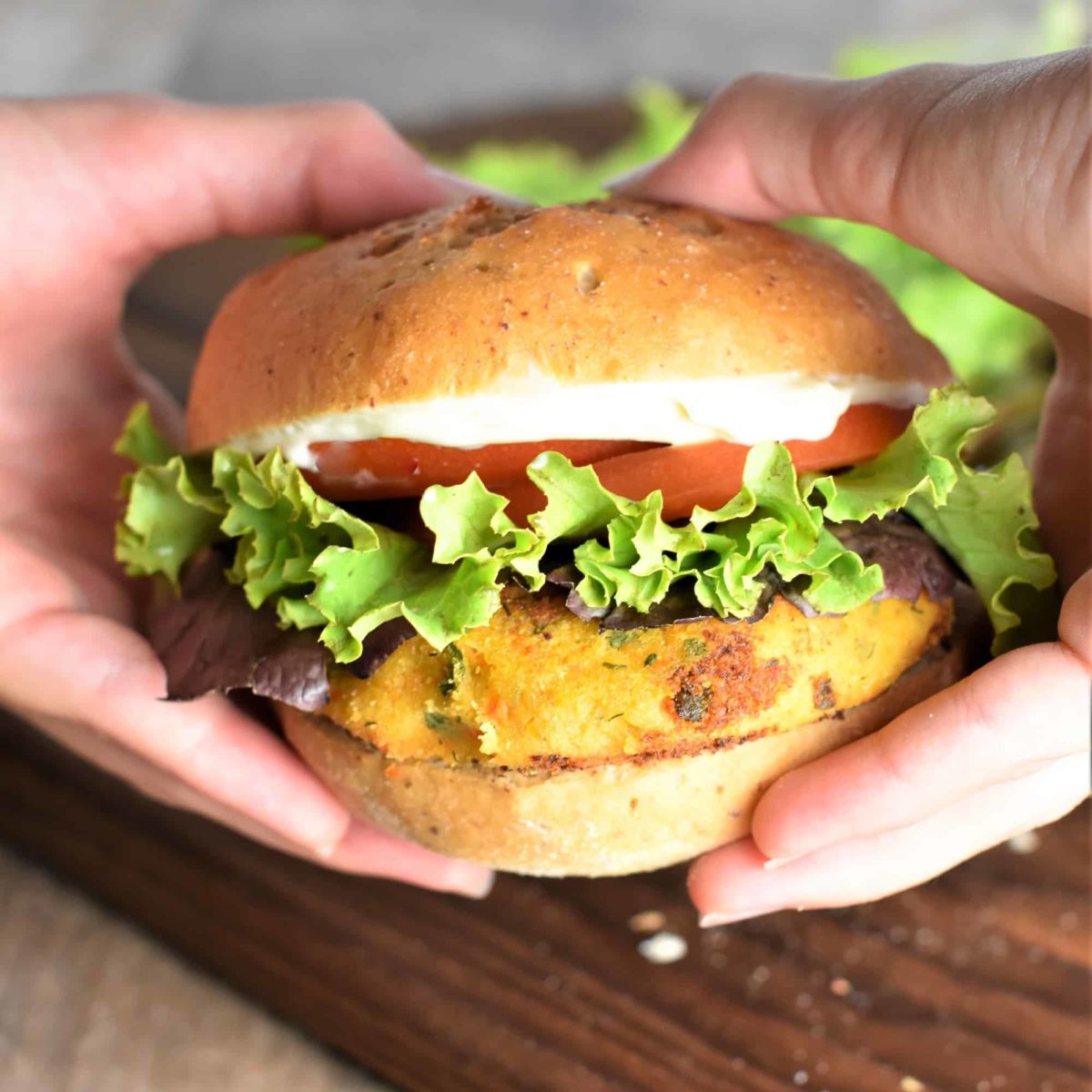 close-up hands holding a burger