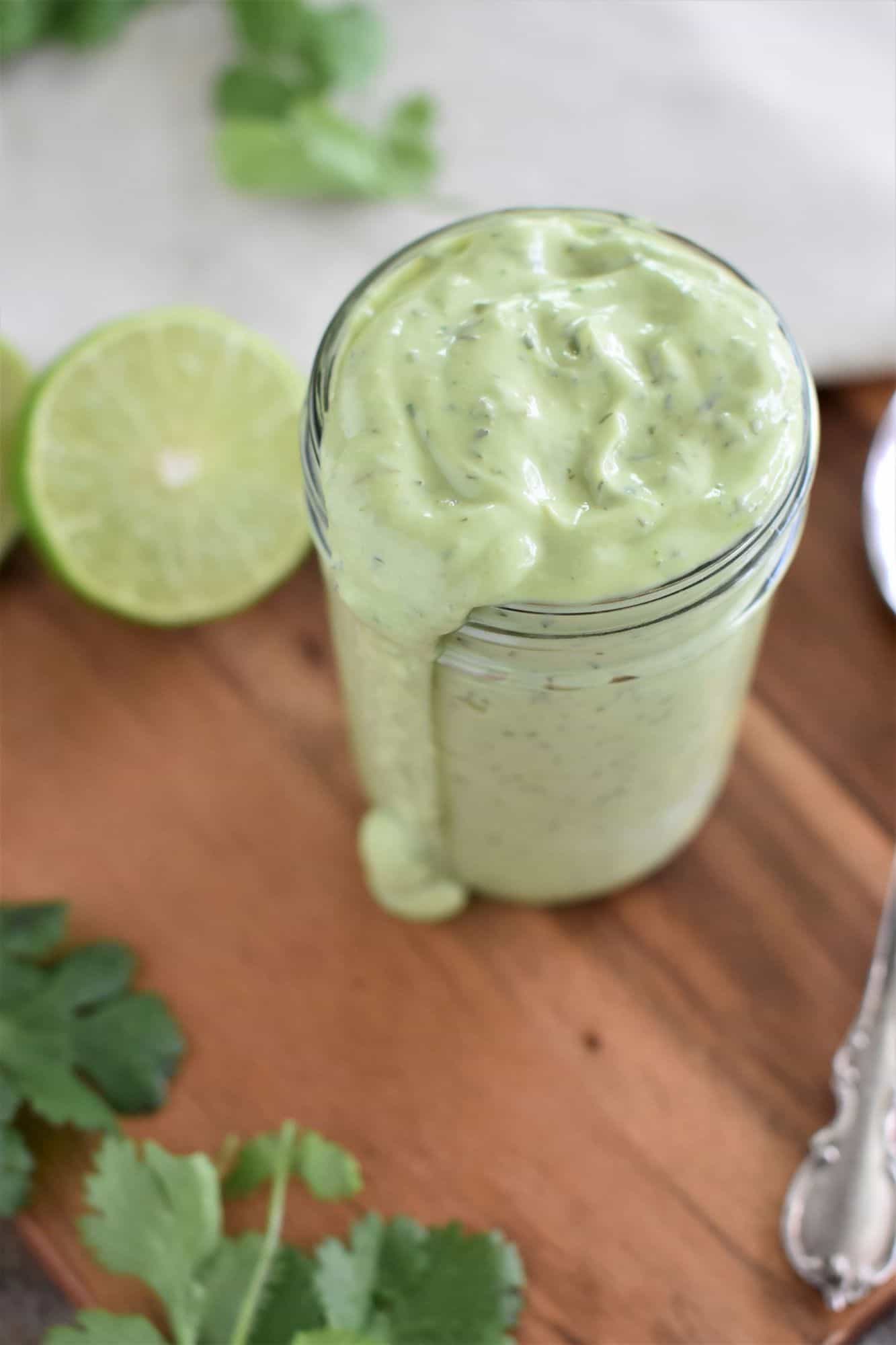vegan avocado ranch dressing in jar with some dripping down side