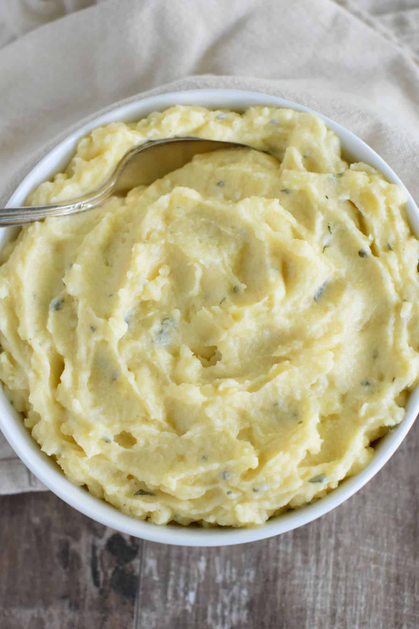 mashed potatoes in white bowl with a spoon in it
