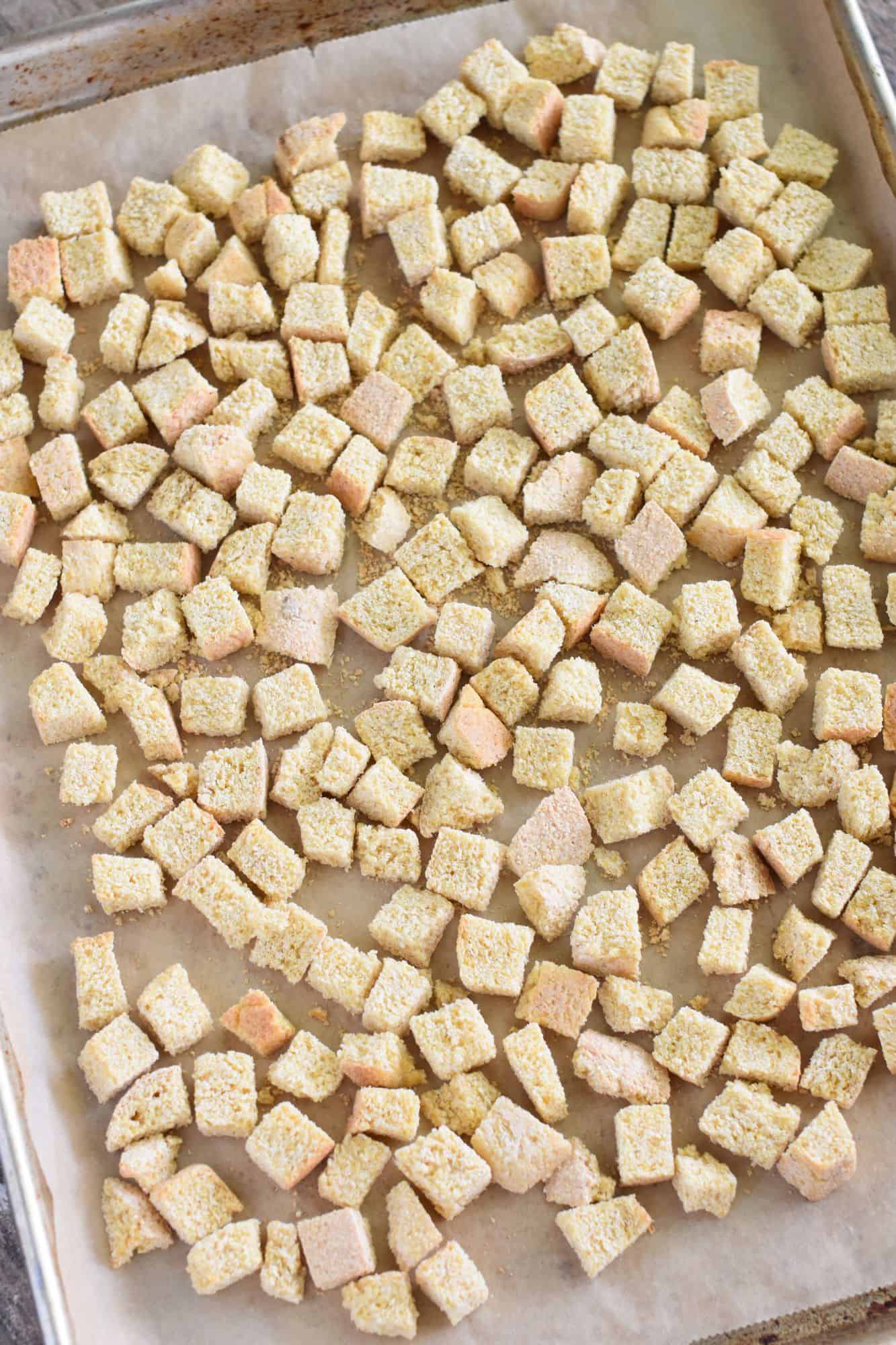 toasted bread cubes on parchment-lined baking sheet