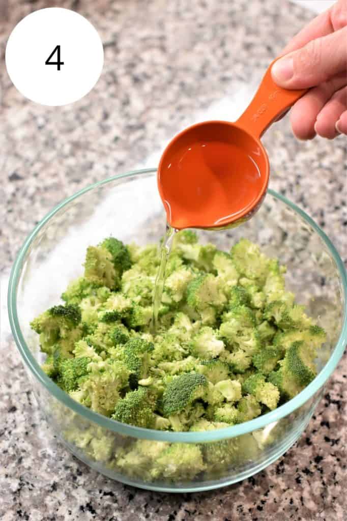 adding water to glass bowl of broccoli florets before microwaving