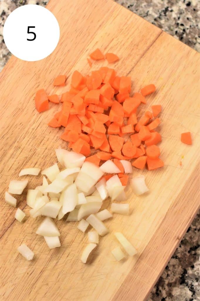 chopped onion and carrots on wooden cutting board