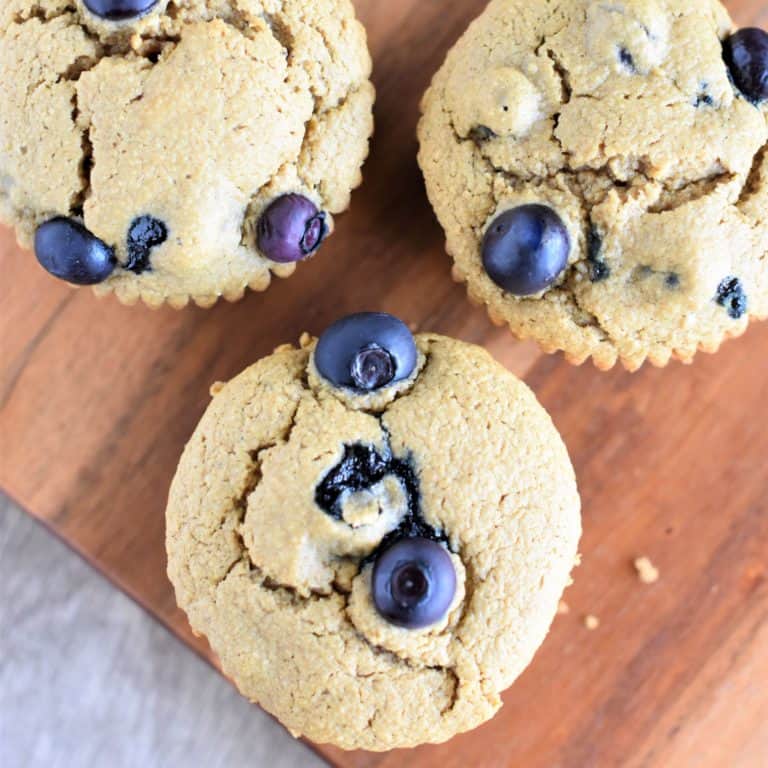 close-up overhead of three muffins on a wood board