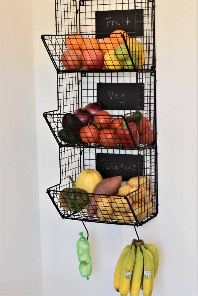 variety of fruits and vegetables in wire hanging rack