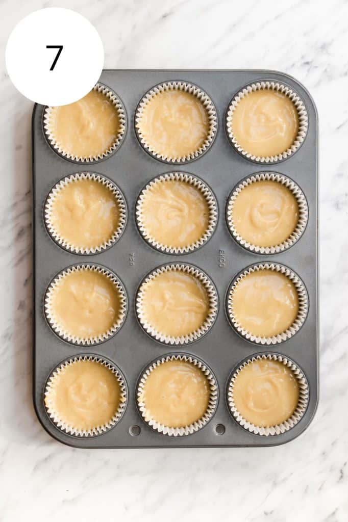 cupcake batter added to baking cups in muffin tin