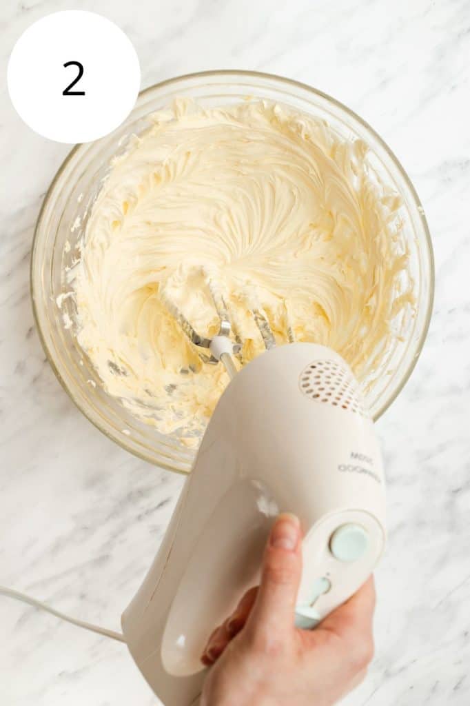 beating vegan butter and vanilla with an electric hand mixer