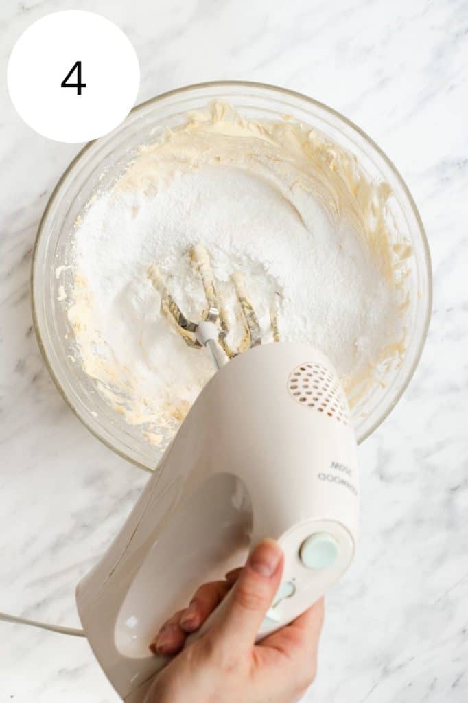 mixing in powdered sugar with an electric hand mixer