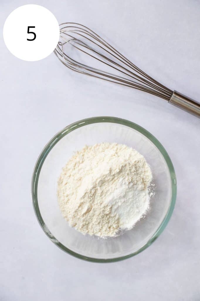 dry ingredients in a mixing bowl with whisk behind it