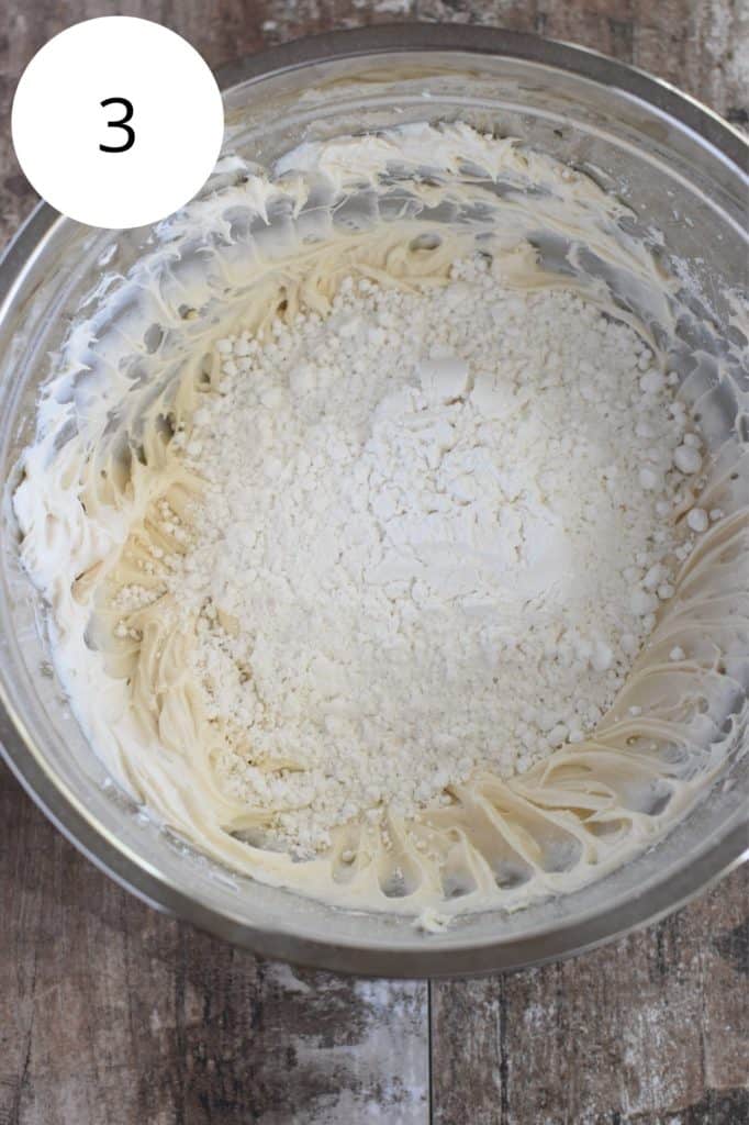 powdered sugar added to frosting in mixing bowl