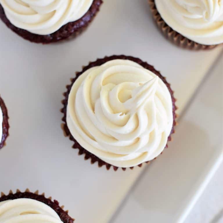 close-up overhead of frosting on a cupcake with parts of others in view
