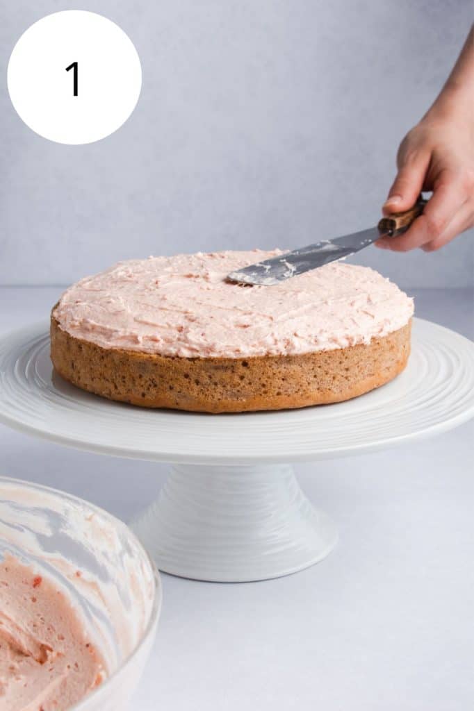 adding frosting to the first cake layer