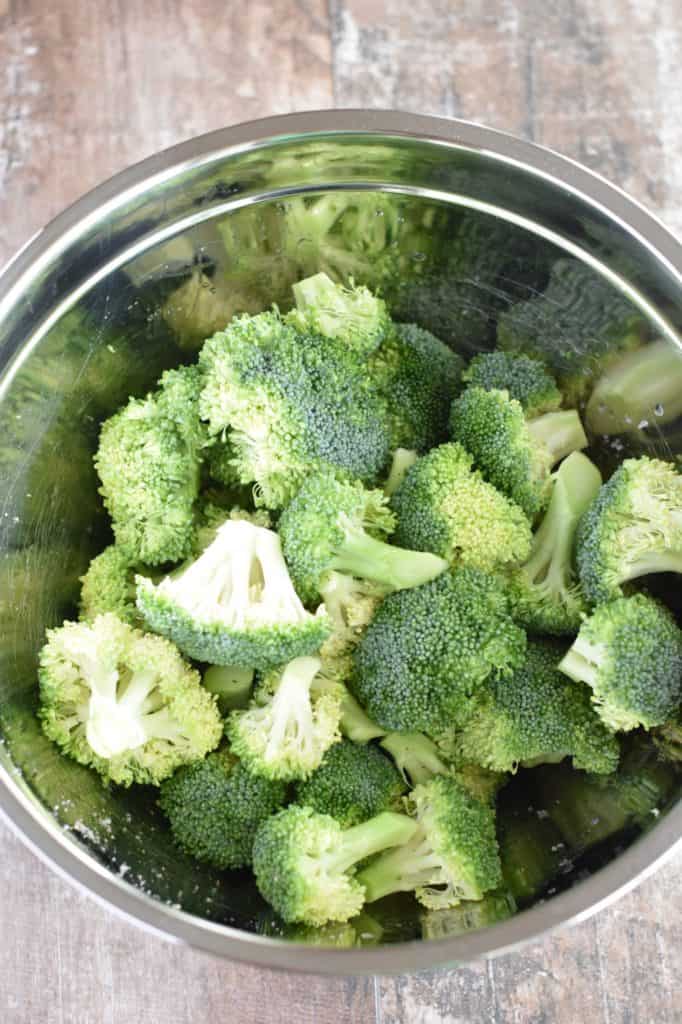 broccoli florets in mixing bowl tossed with olive oil, salt and pepper