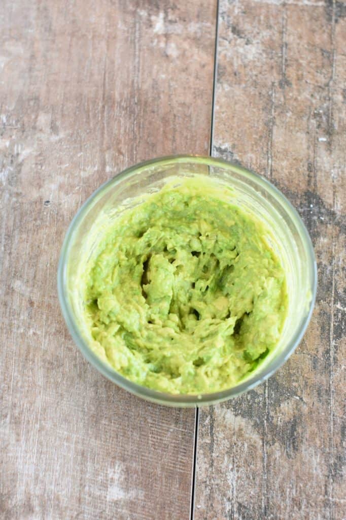 mashed avocado and lemon juice in small glass bowl