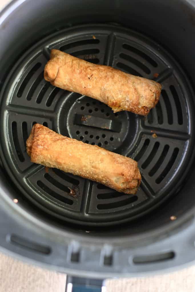 egg rolls in air fryer basket after cooking