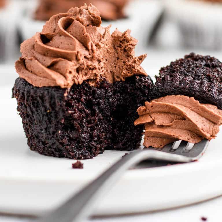 cupcake on white plate with piece taken out and on fork next to it