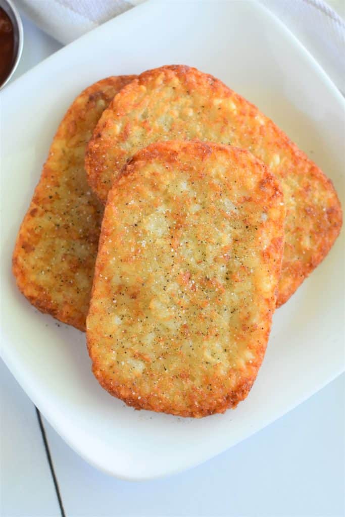 overhead of 3 hash brown patties with salt and pepper