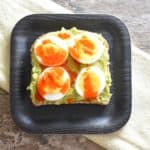 close-up of avocado toast with boiled egg and hot sauce