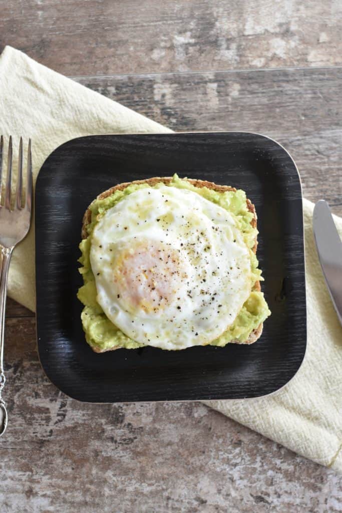 overhead of slice of avocado toast with fried egg