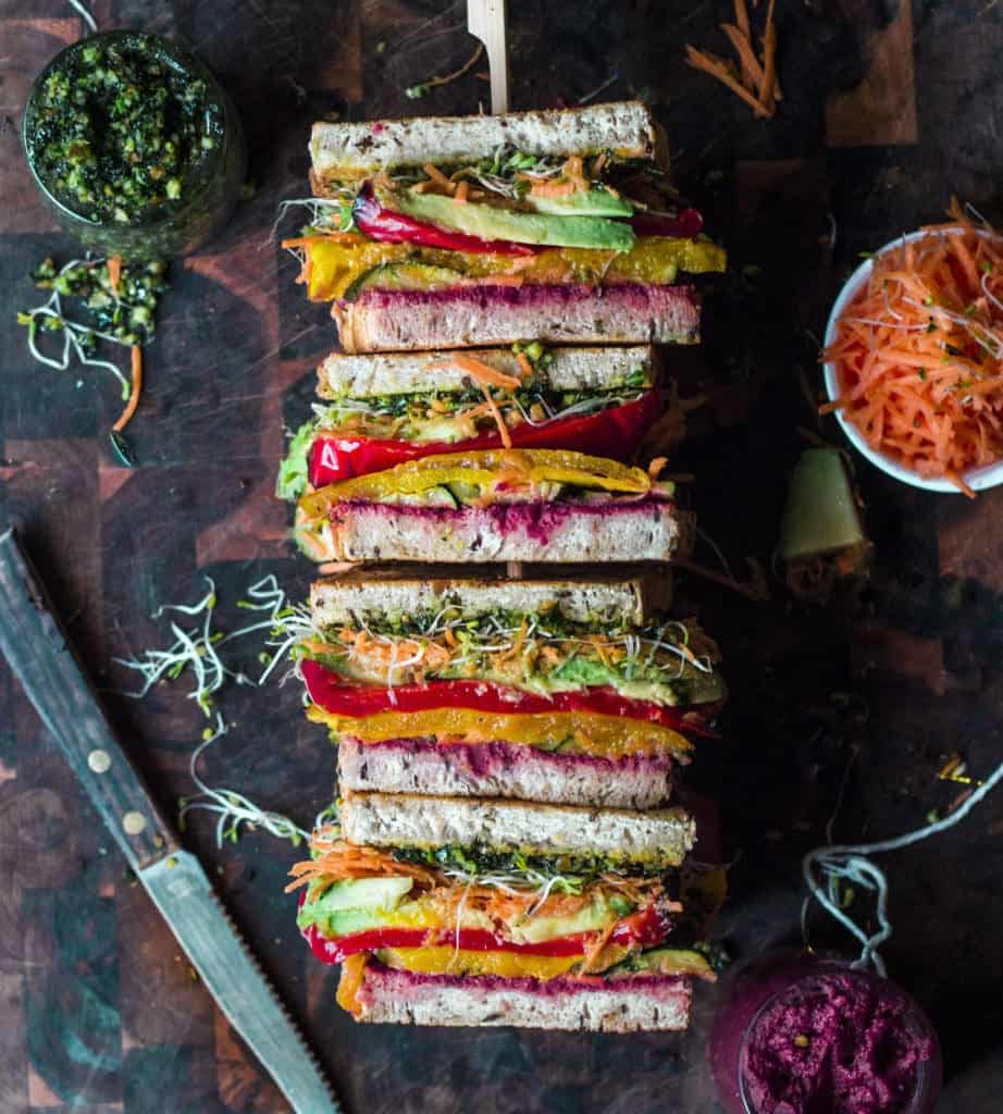 roasted veggie sandwiches face up o a wooden board