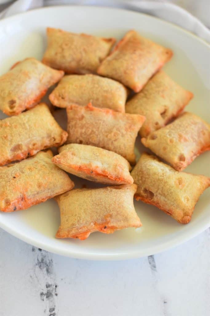 front view of pizza rolls on a white plate