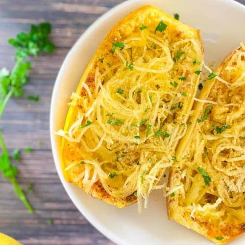 air fryer spaghetti squash in white serving bowl topped with vegan Parmesan and parsley