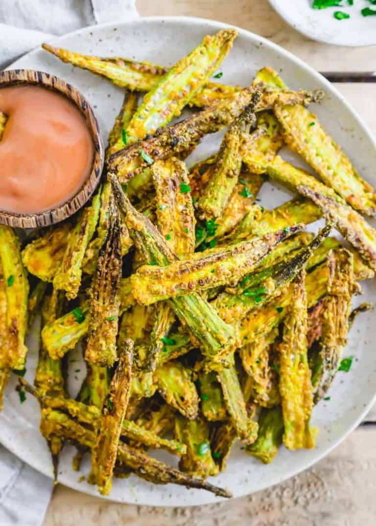 air fryer okra on white plate with side of dipping sauce