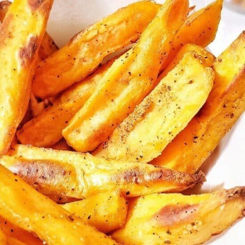air fryer sweet potato fries in a white serving bowl with napkins in it