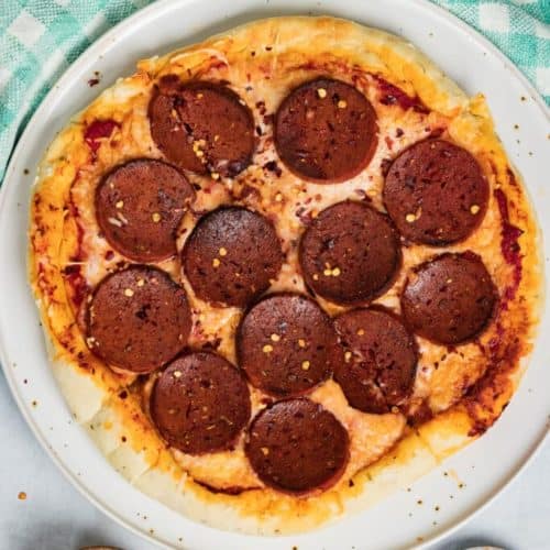 overhead of vegan pepperoni pizza topped with crushed red pepper