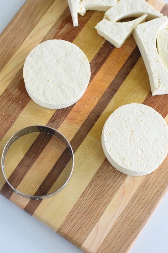 tofu cut into circles with cookie cutter on wooden board