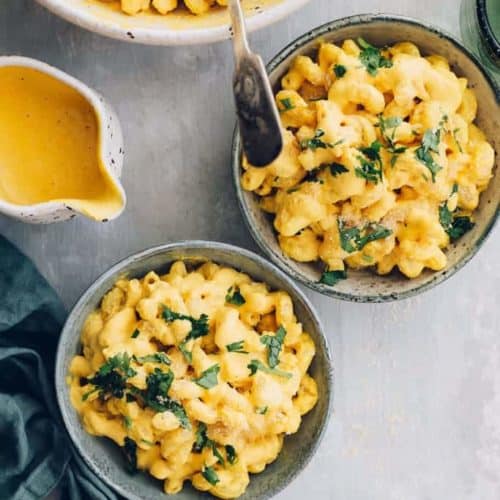 overhead of two portions of vegan mac and cheese with more behind them