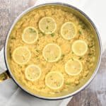 close-up overhead of lemon risotto in pan garnished with lemons