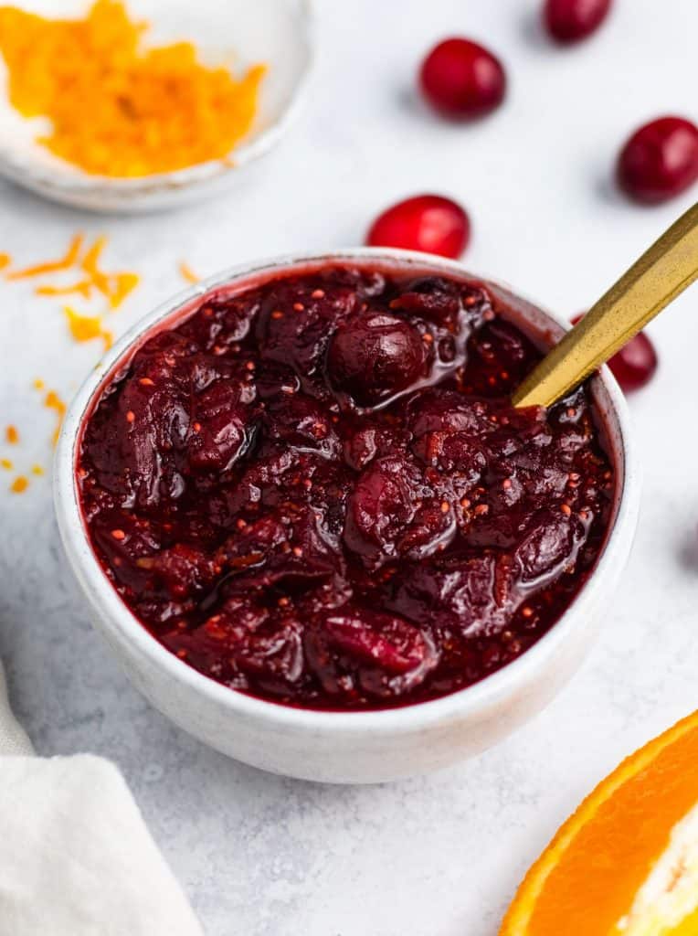 overhead of cranberry sauce in serving bowl with spoon in it