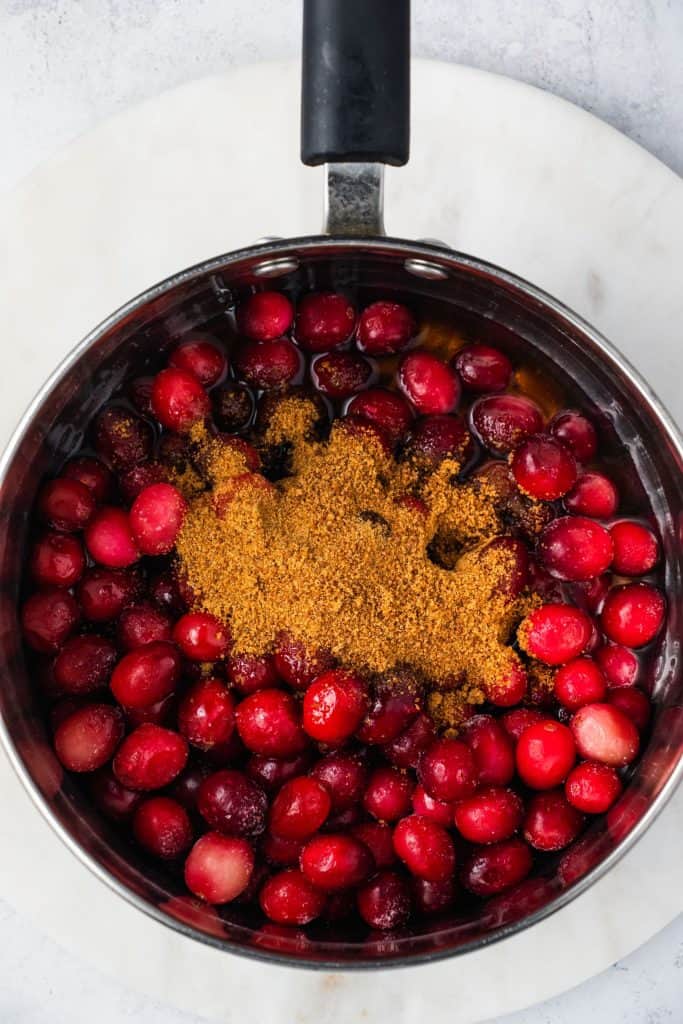 cranberries, water, maple syrup and sugar added to a large saucepan