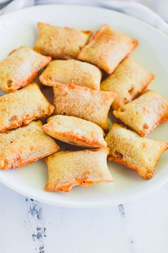 front view of pizza rolls on a white plate.