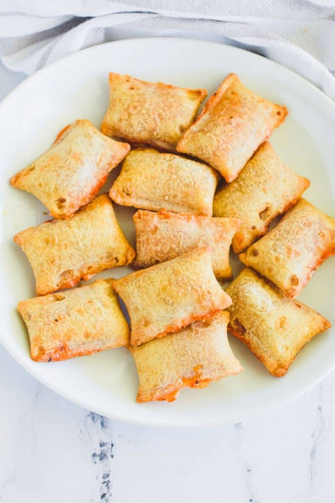 overhead view of pizza rolls on a white plate.