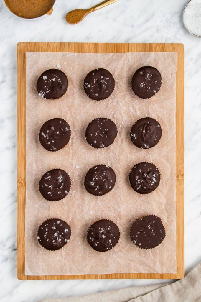 overhead of 12 peanut butter cups on paper on a wooden board