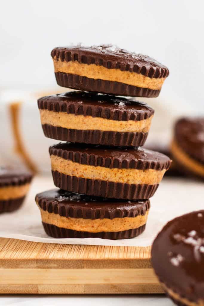 stack of four peanut butter cups on paper on a wooden board