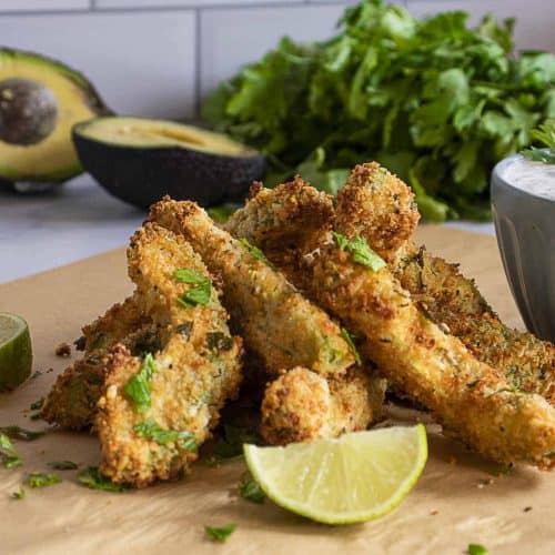 avocado fries on parchment paper with lime wedge