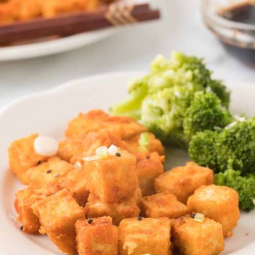 crispy tofu on white plate with side of broccoli