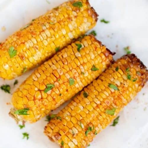 overhead of corn on the cob on white plate