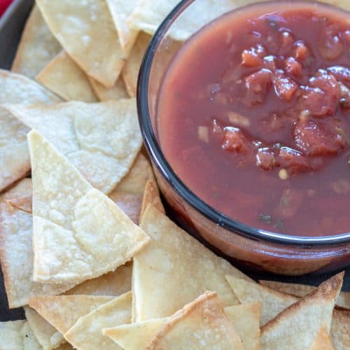 plate of tortilla chips with side of salsa dip