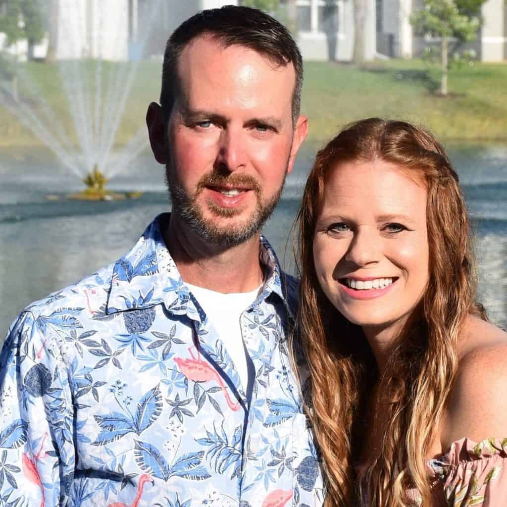 Greg and Sherri posting for a photo together in front of a fountain and lake

