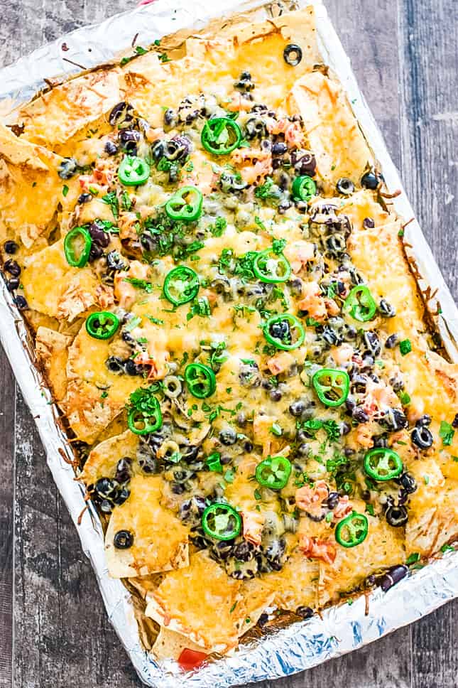 overhead of vegetarian nachos on a sheet pan after baking and topped with fresh cilantro