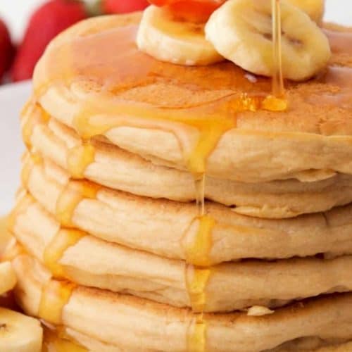 close-up view of stack of vegan pancakes with syrup dripping down the front.