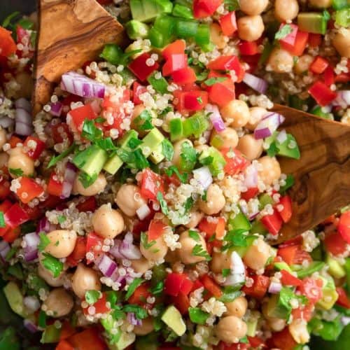 quinoa chickpea salad with two wooden spoons.